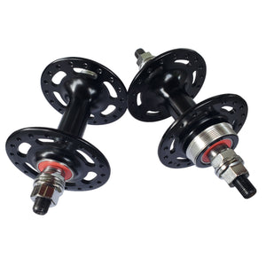 Two bicycle hubs on a white surface with a neutral background