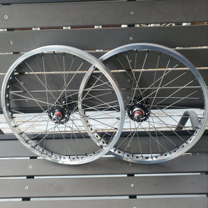 Two bicycle wheels stacked against a metallic background