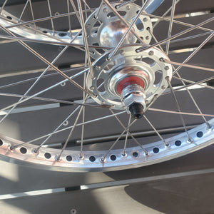 Close-up of a bicycle wheel hub with metallic finish