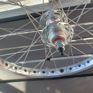 Close-up of a bicycle hub and spokes against a neutral background