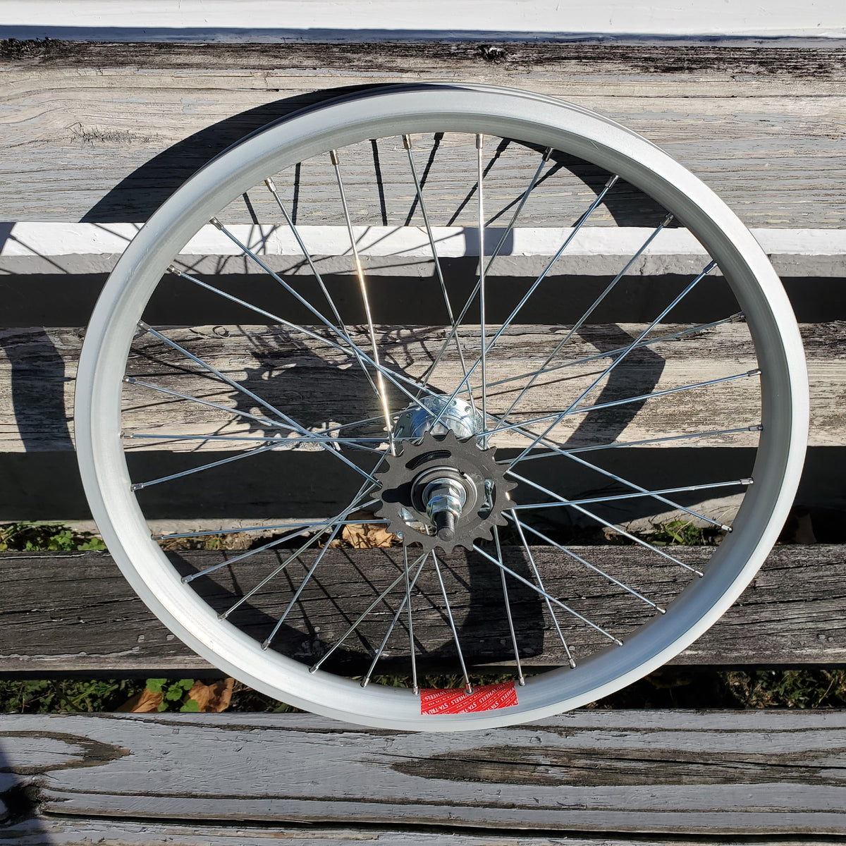 Bicycle wheel against a wooden fence background