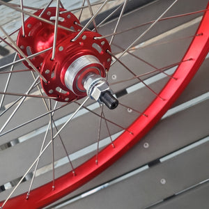 Close-up of a bicycle wheel with red rim and red hub.