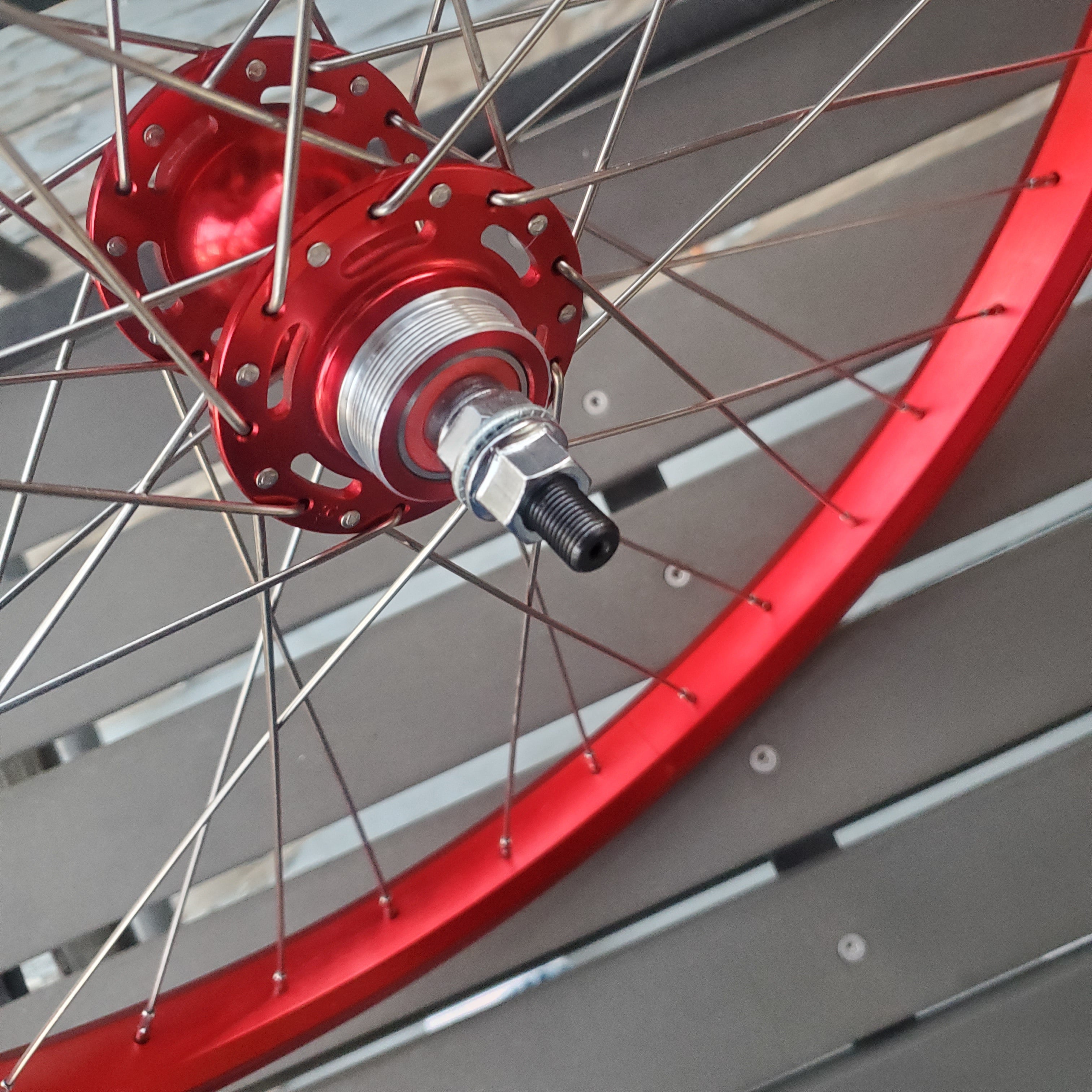 Close-up of a bicycle wheel with red rim and red hub.