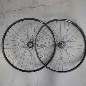 Two bicycle wheels on a gray concrete floor