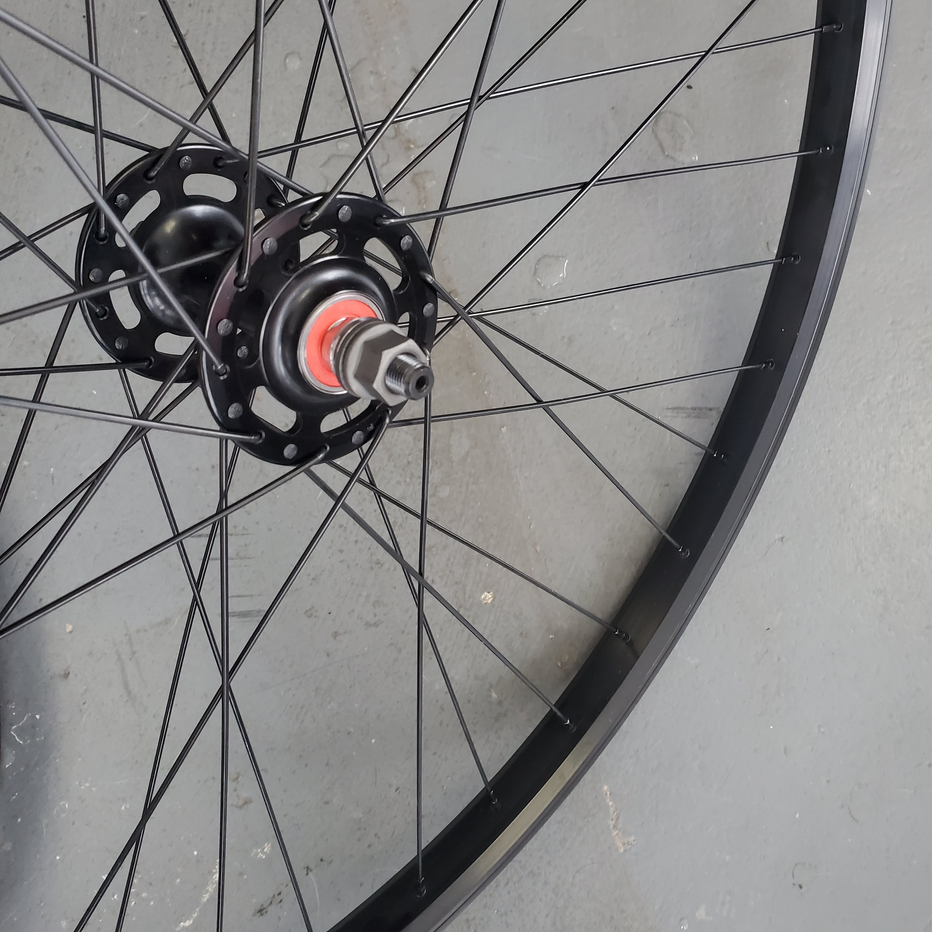 Close-up of a bicycle wheel hub on a gray surface