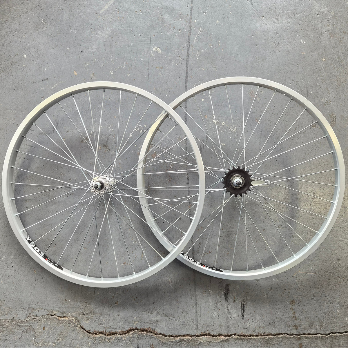Two bicycle wheels on a concrete surface