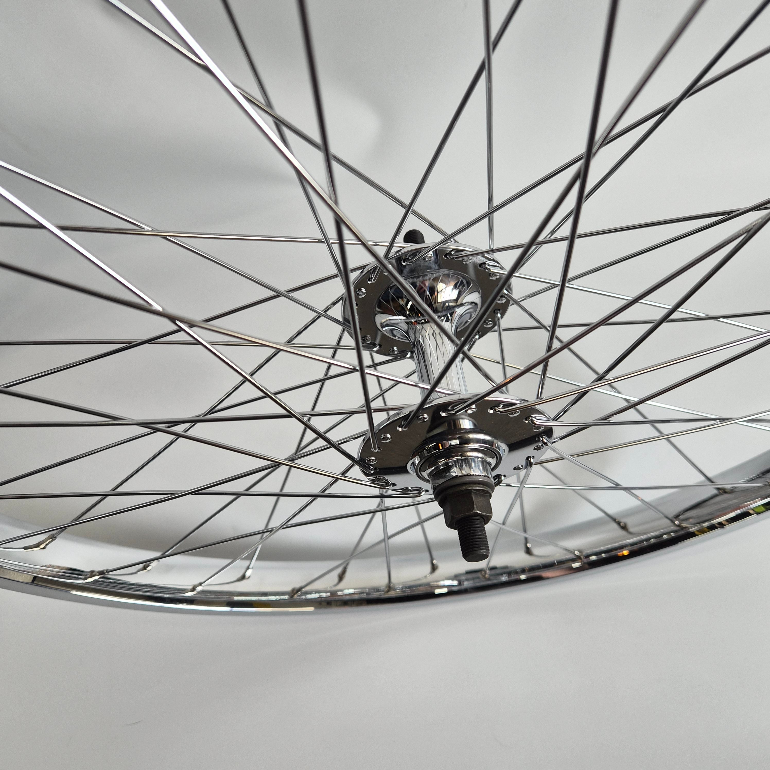 Close-up of a bicycle wheel with hub and spokes on a light gray background