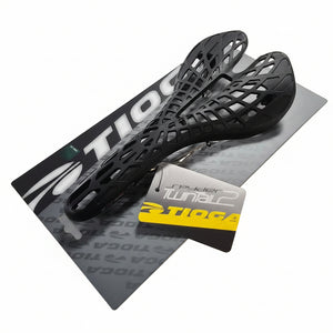 Black bicycle seat on a white surface with a brand card underneath