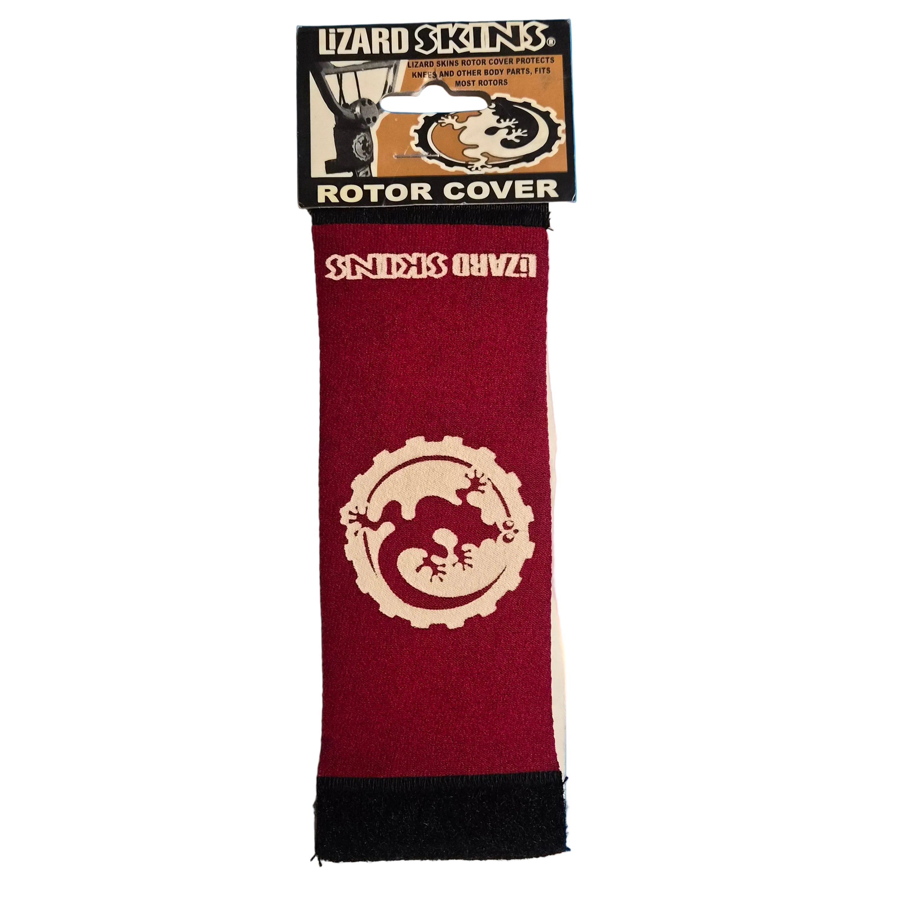 A packaged red and beige lizard-themed disc golf rotor cover labeled 'Lizard Skins' and 'Snicks Oh Vva', standing upright on a bright blue disc with a blurred white logo in the background.