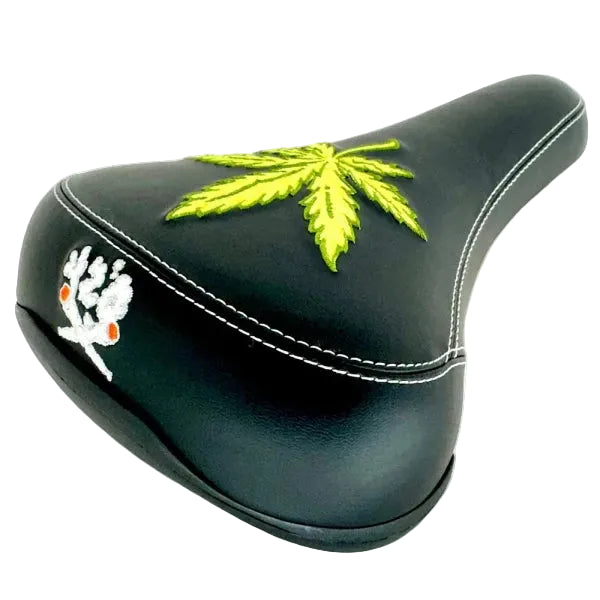 Black bicycle seat with embroidered green leaf design on a white background