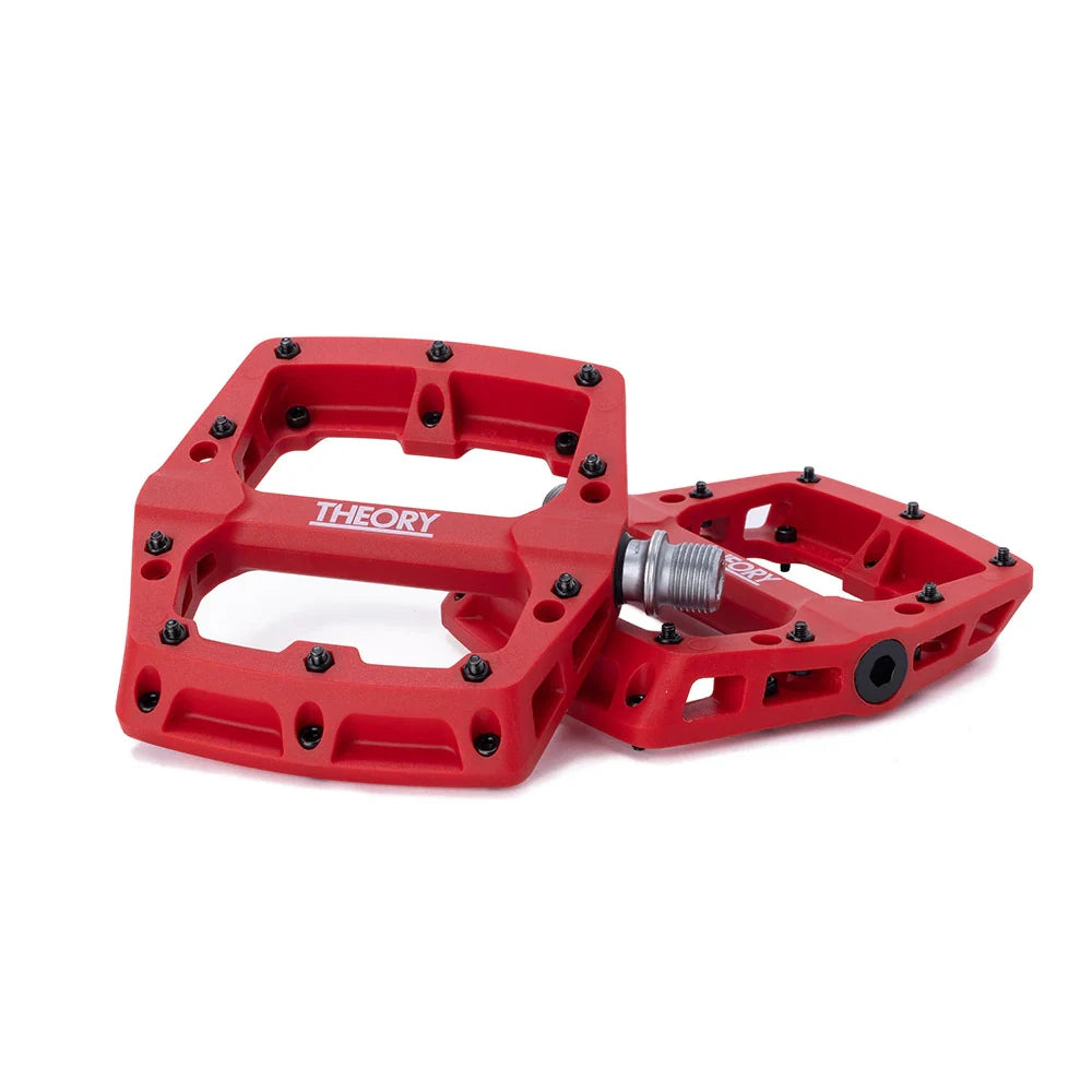 Two red bicycle pedals on a white background