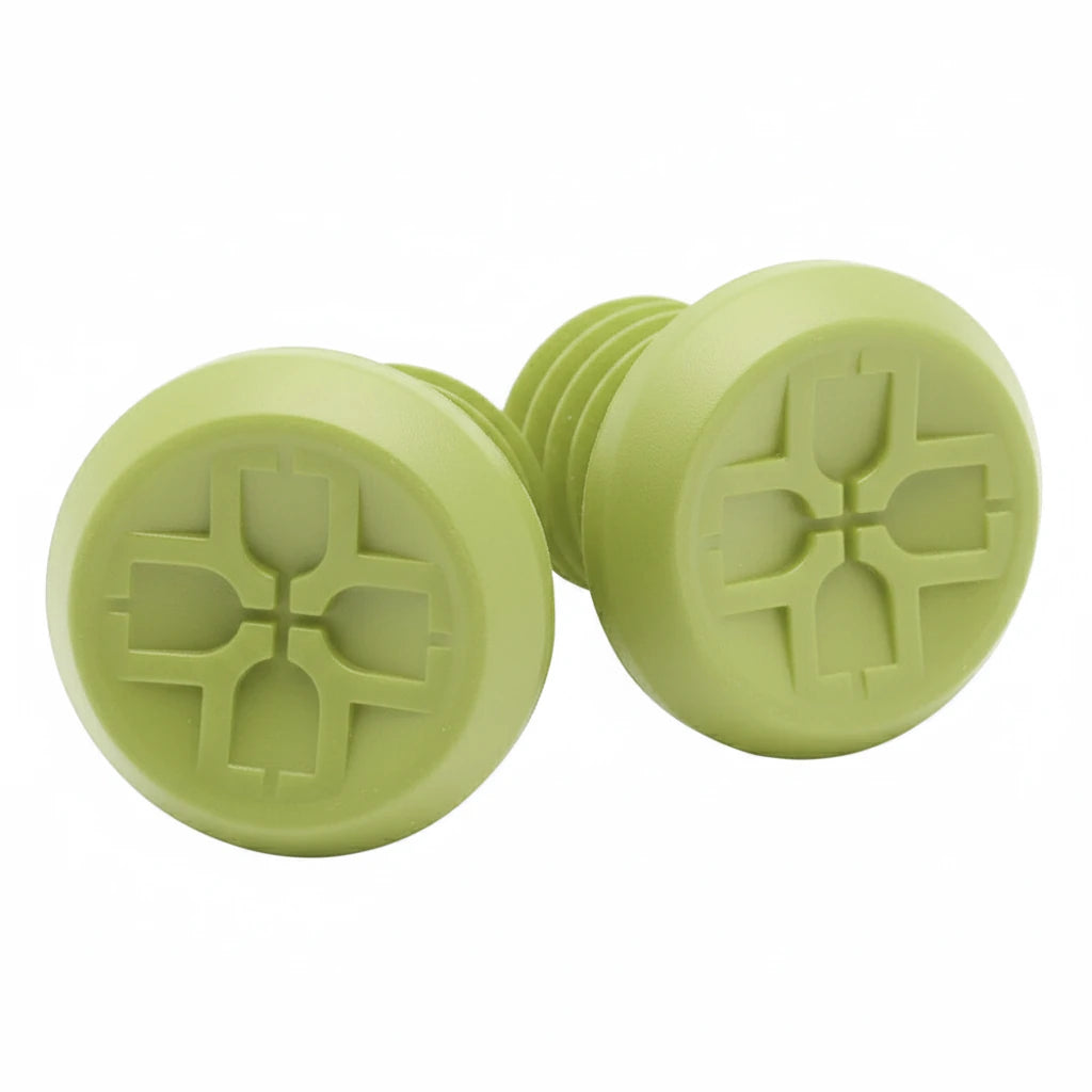Two green silicone bottle plugs with a unique design on a white background