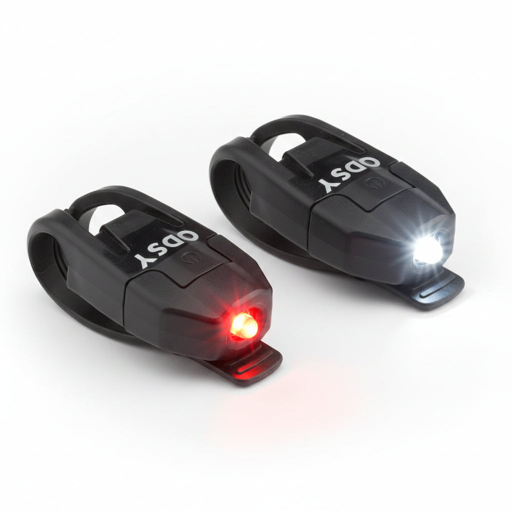 A pair of Odyssey BMX LED bike lights, one with a white light and one with a red light, both with black housing.